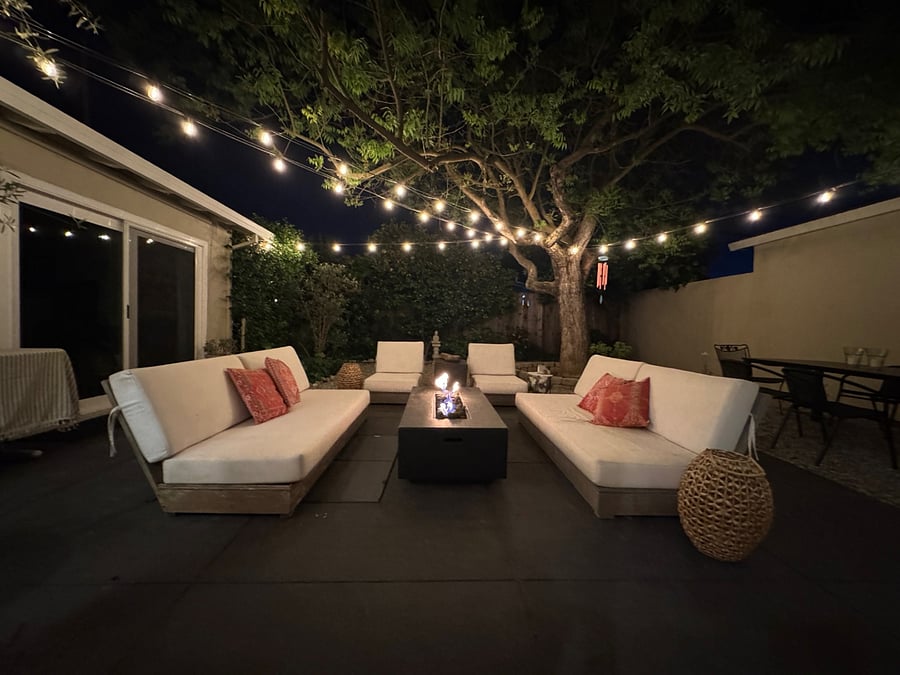 Backyard patio with firepit and outdoor lighting