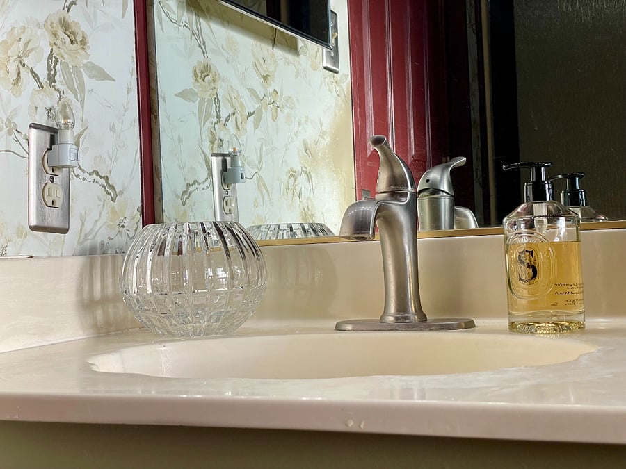 Turn faucet left for hot water, right for cold. Sink stopper presses down to fill sink. Hand soap provided.