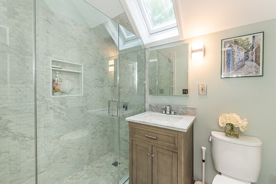 Newly renovated bathroom with a large walk-in shower and skylight to bring in natural light.