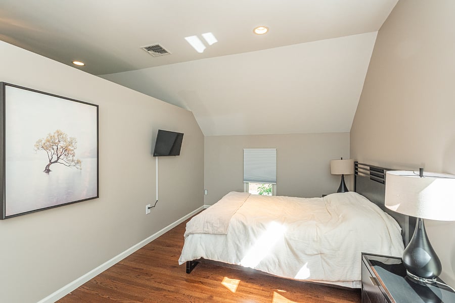 Queen bed with 40" Smart TV in bedroom.