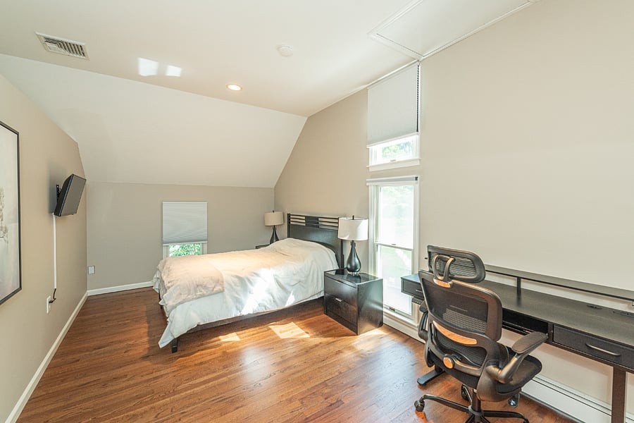 Very spacious bedroom with plenty of natural light and a large working desk.