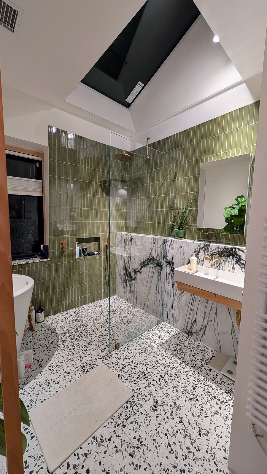 Walk-in shower with rain-head; skylight above