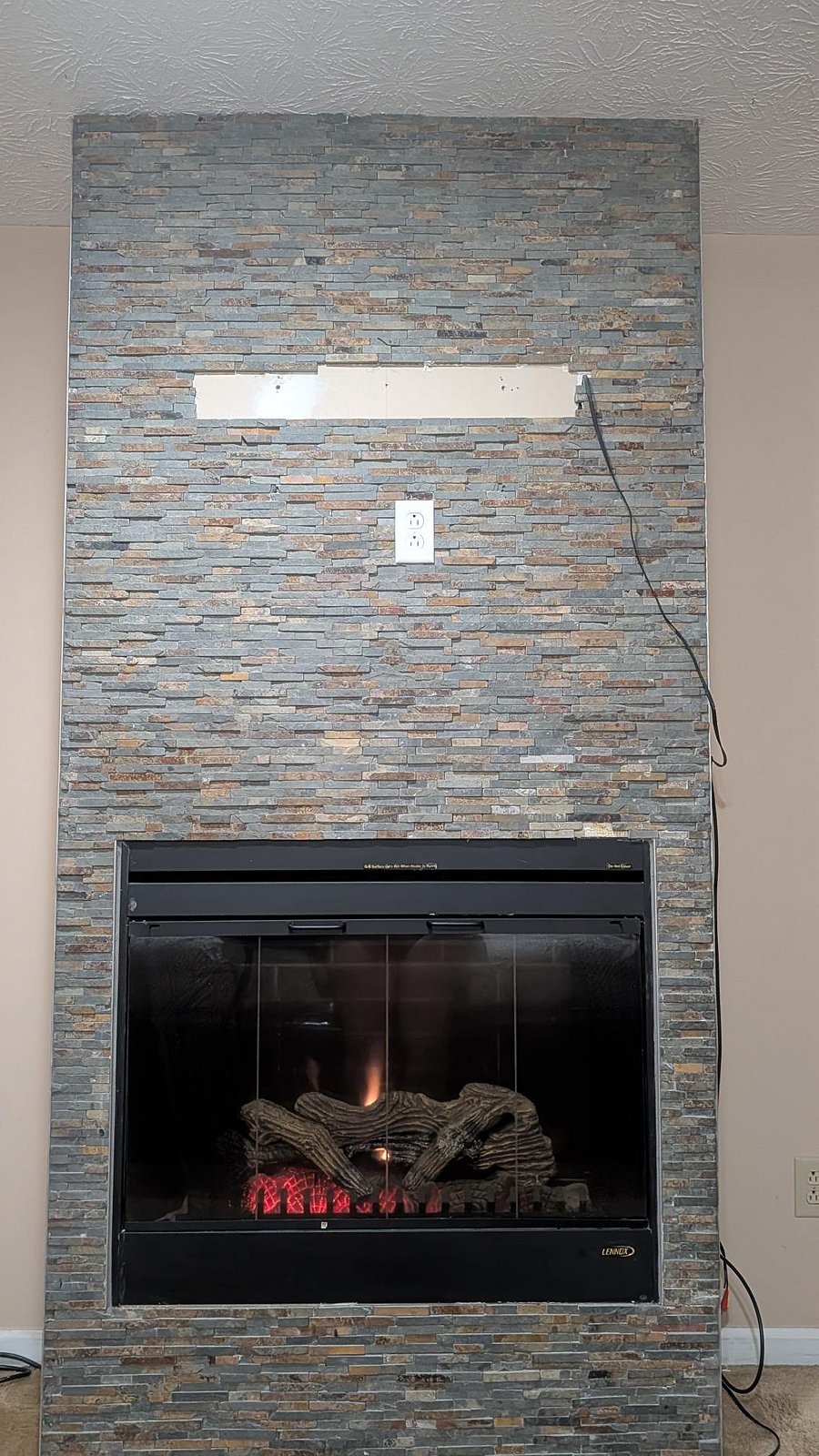 Stone-accent fireplace creates a natural focal point, offering a comfortable gathering spot for relaxing evenings.
