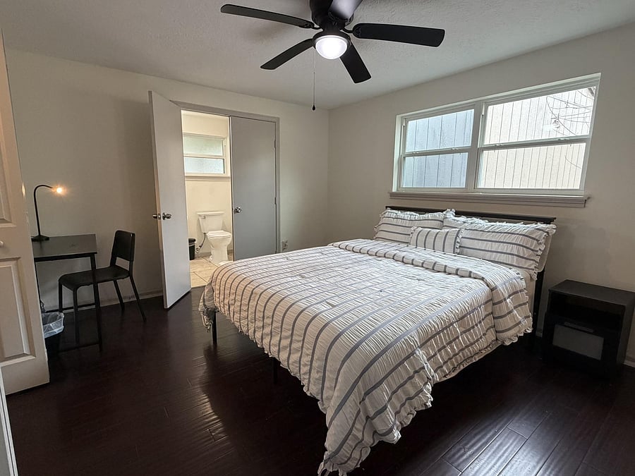 Room 5 - queen size bed, private bath, two closets, large window, desk, chair, nightstand, ceiling fan, and lamp