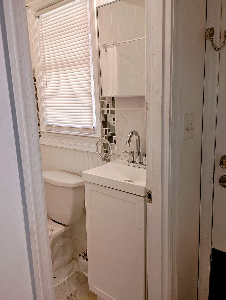Renovated full private bath /shower, vanity, elongated faucet, mirrored medicine cabinet, and window with blinds for privacy.
