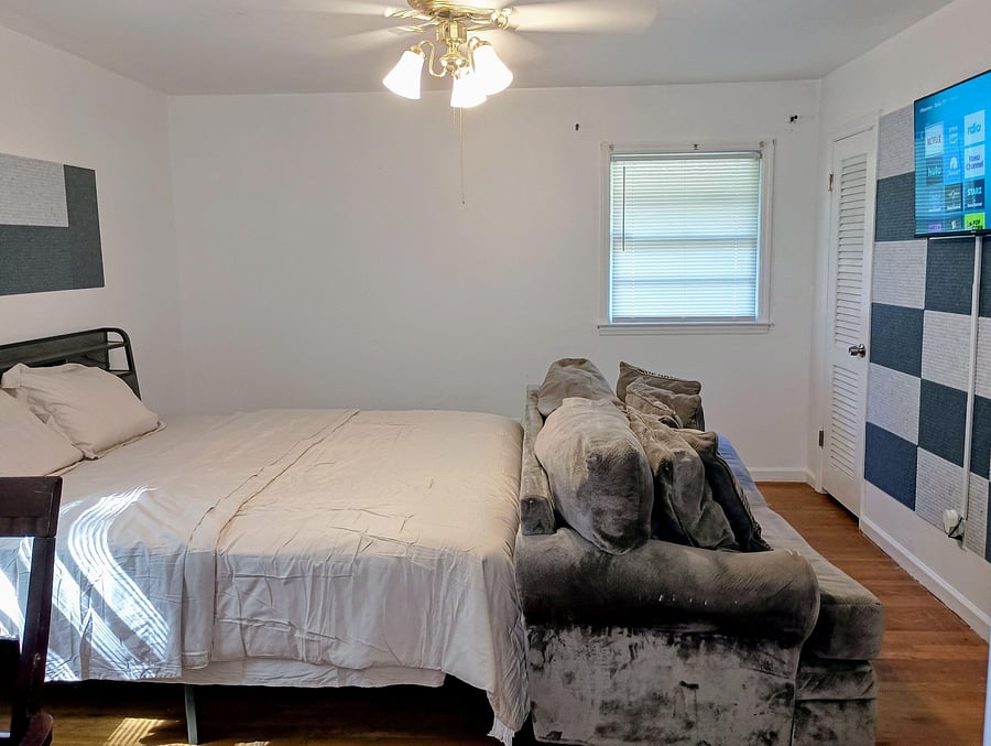 Private bedroom with a full-size bed, window with blinds, ceiling fan light, and convenient closet storage.