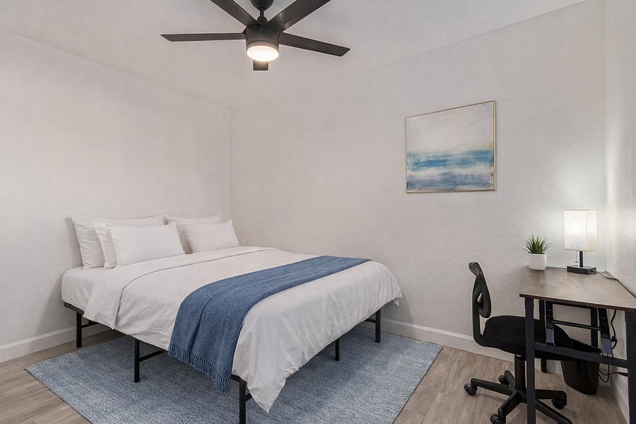 Queen Bed and spacious closet. Ceiling Fan and Desk and Chair. Bedding and rug virtually staged.