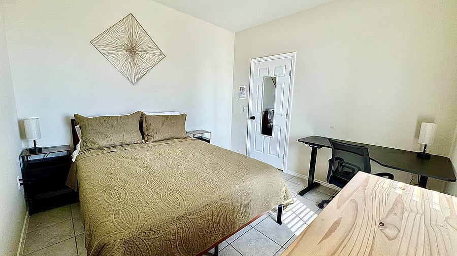 Bright downstairs room with easy access. Features a queen bed, large desk, dresser and clean tile floors.
