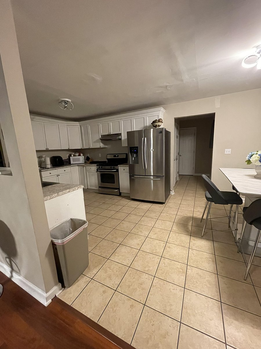 Large kitchen with dining table and modern appliances.
