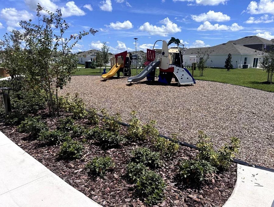 Neighborhood playground and green space with walking paths and landscaped areas for outdoor recreation.