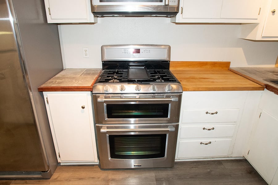 Full kitchen features plenty of cabinet space with a microwave, stove, oven, and two refrigerators.