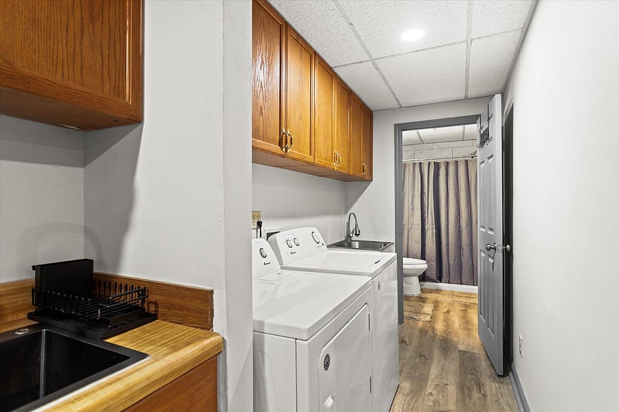Downstairs laundry room equipped with washer, dryer, and laundry sink.