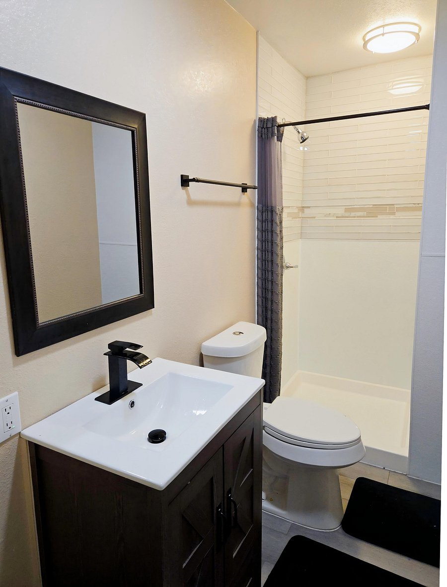 Full bath with a modern vanity, framed mirror, and a tub/shower combo with tiled surround for easy maintenance.
