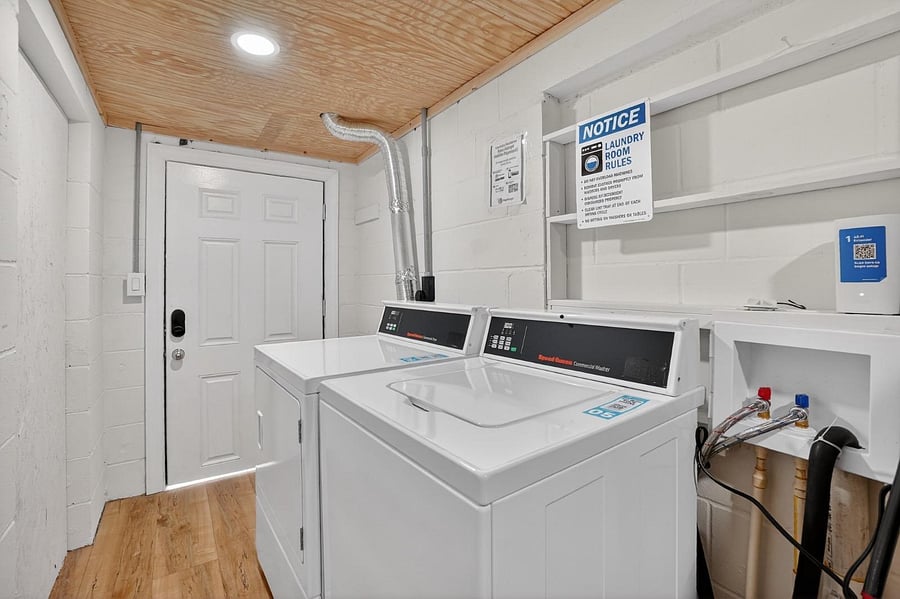 Dedicated laundry room with commercial-grade washer and dryer, built-in shelving, and easy access for day-to-day use.