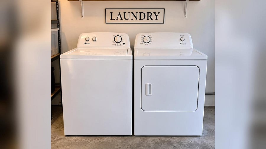 Dedicated laundry area with full-size washer and dryer and convenient shelving for supplies and storage.