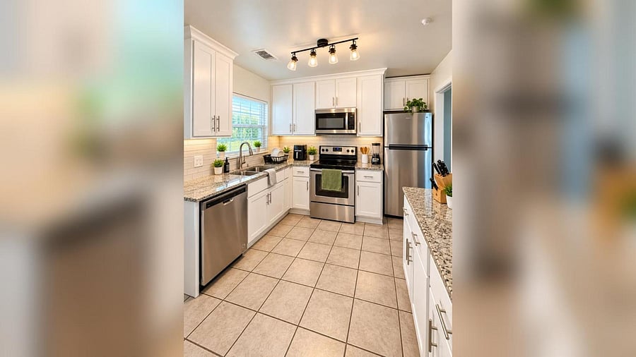 U-shaped kitchen with granite counters, ample white cabinetry, and stainless steel appliances including dishwasher and microw