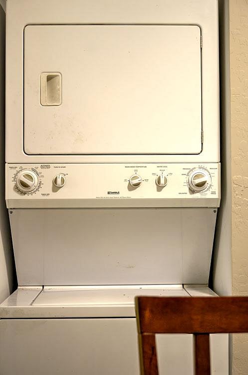 In-home stacked washer and dryer setup offers convenient laundry access for residents.