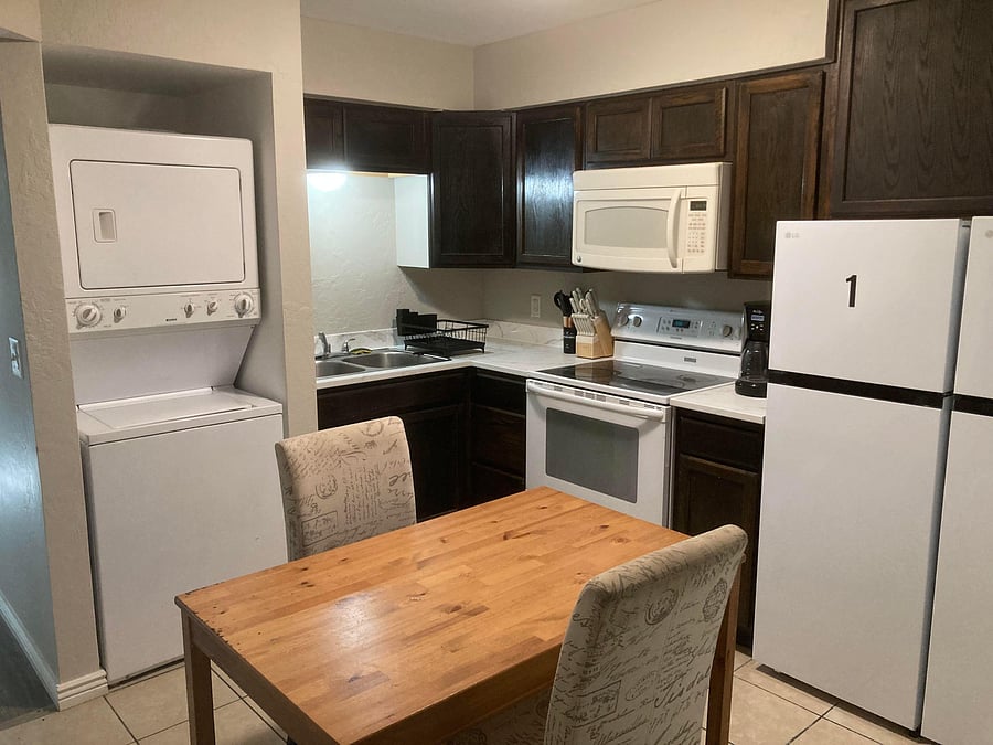 Efficient eat-in kitchen with ample cabinetry, full appliances, and an in-unit stacked washer/dryer for added convenience.
