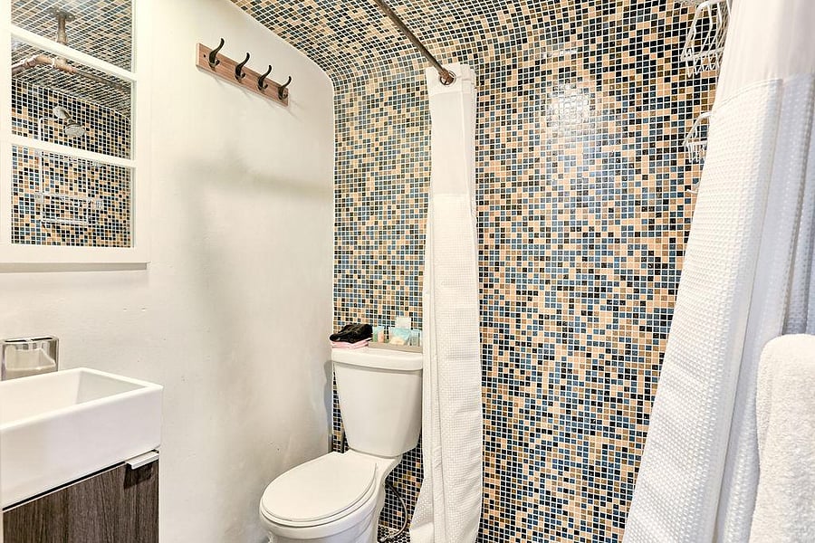 Shower with curtain is available in this shared, updated bathroom.