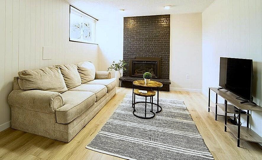 Lower-level living room with gas fireplace and Smart TV