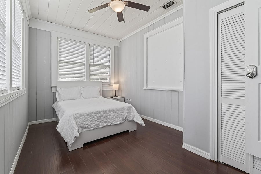 This room with TV and ceiling fan gets lots of natural light