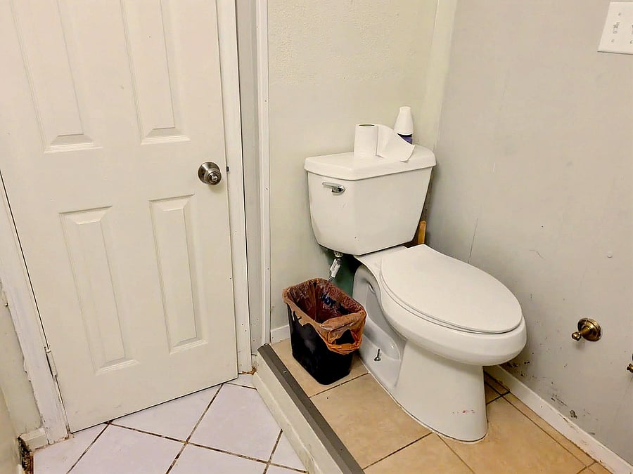 Compact bathroom with tiled flooring, standard toilet, and easy access via a paneled interior door.