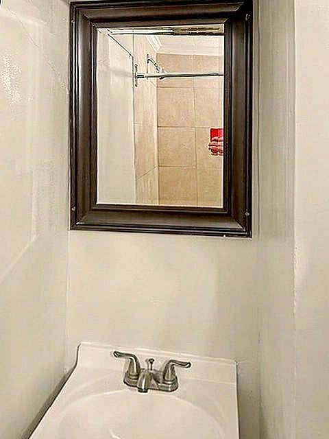 Compact vanity area with framed mirror and single-basin sink for convenient daily routines.