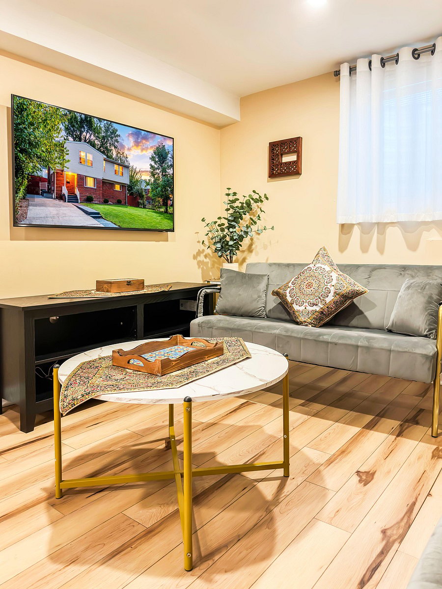 Comfortable living area with a sectional sofa, wall-mounted TV, and a coffee table--ideal for relaxing or entertaining.