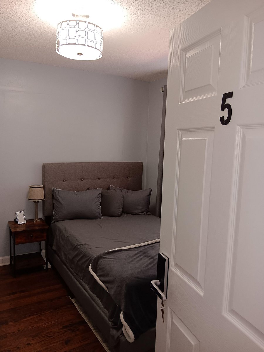 Private bedroom with a furnished bed, bedside table and lamp, and durable flooring for easy upkeep.