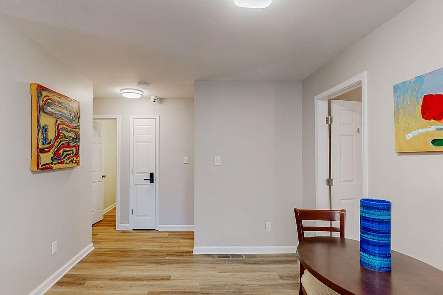 Downstairs hallway, dining and shared bathroom entrance.