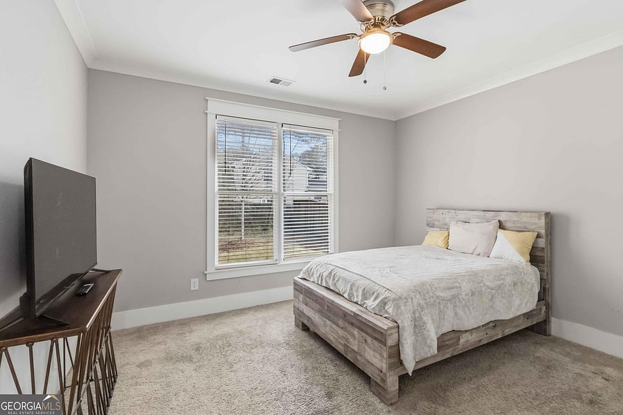 Bedroom features a large window with blinds, ceiling fan light, and space for a full/queen bed plus a TV or dresser.