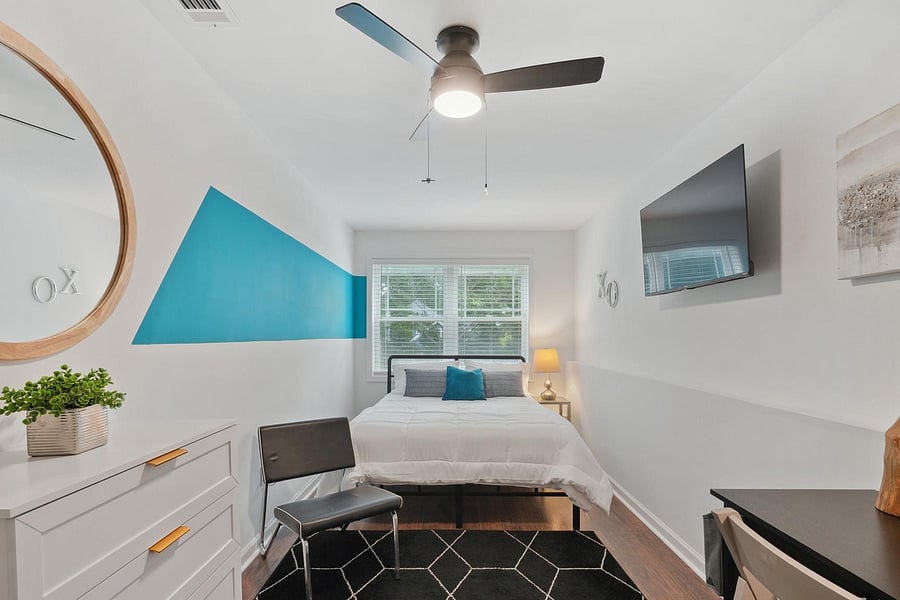 Includes a Queen Bed, Dresser, Sitting Chair, Large TV and Work Desk