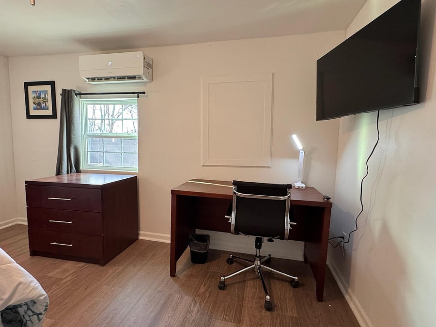 Work station with desk, ergonomic chair, and a smart TV
