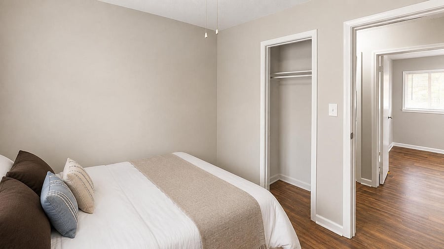 Bedroom features wood-style flooring, neutral walls, and a reach-in closet, with easy access to the hallway and nearby rooms.