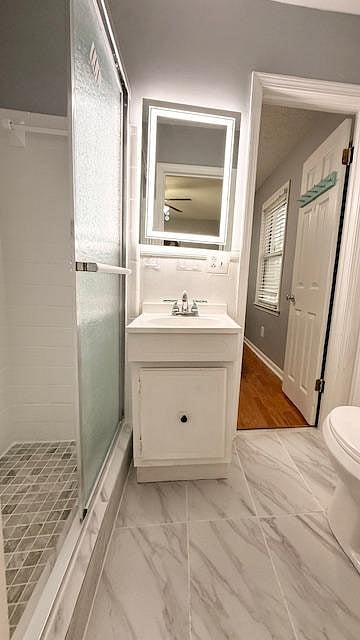 Full bathroom with tiled shower that is shared between Room 3 and 4