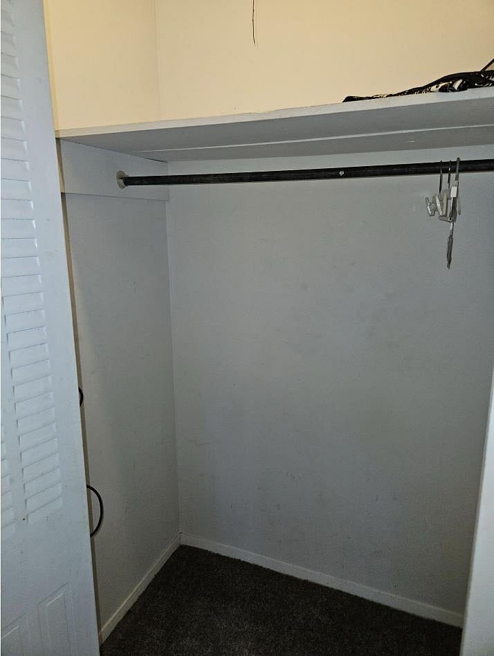 Reach-in closet provides hanging space and an overhead shelf for storing clothing, shoes, and personal items.