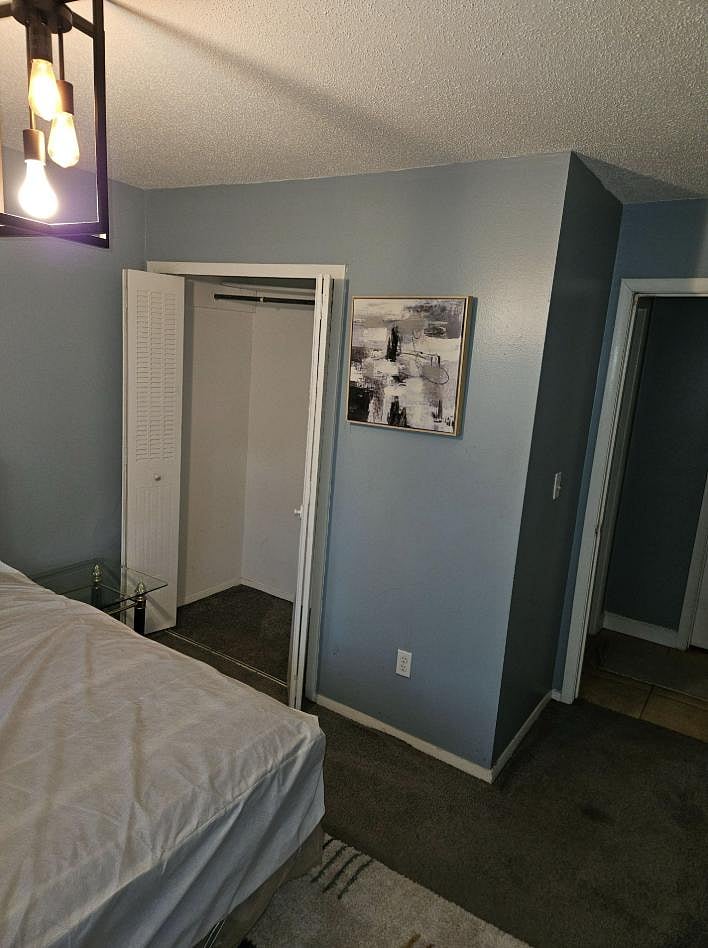 Private bedroom with carpeted flooring, overhead lighting, and a closet for everyday storage plus easy hallway access.
