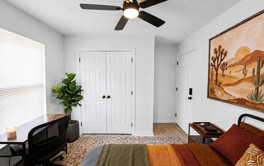 Bedroom with a ceiling fan, large window with blinds, double-door closet, and space for a work-from-home desk.