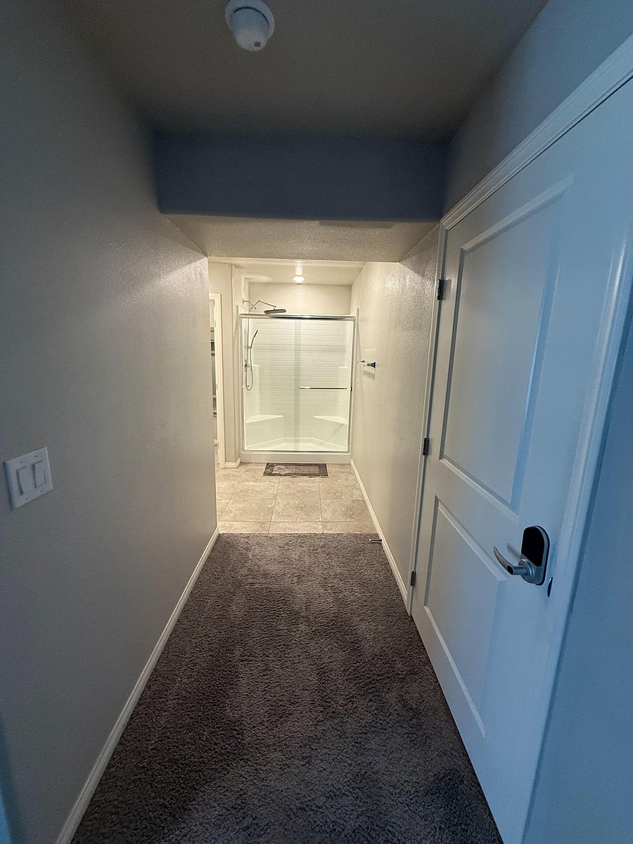 Full bathroom with a glass-enclosed shower, tiled flooring, and clean finishes for easy daily use.