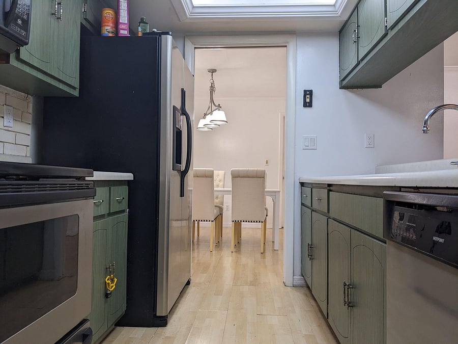 Galley kitchen with ample cabinet storage, full-size appliances, and a direct flow into the adjacent dining area.