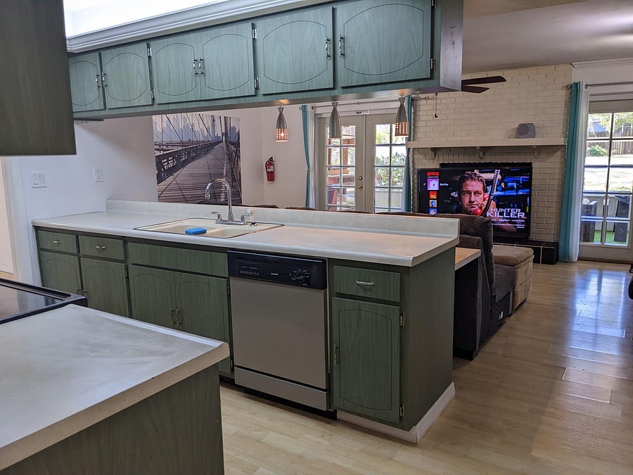 Open kitchen with generous counter space, ample cabinetry, and a dishwasher, flowing into the adjacent living area.