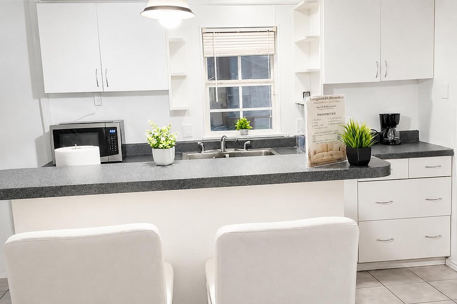 Clean kitchen with generous counter space, ample cabinetry, and a breakfast bar seating area by the sink window.