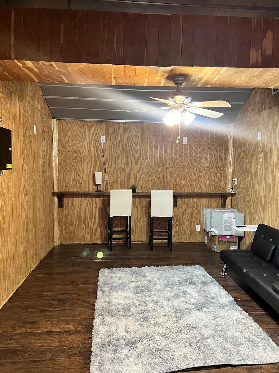 Versatile bonus room with wood paneling, ceiling fan lighting, and a built-in counter for work or casual seating.
