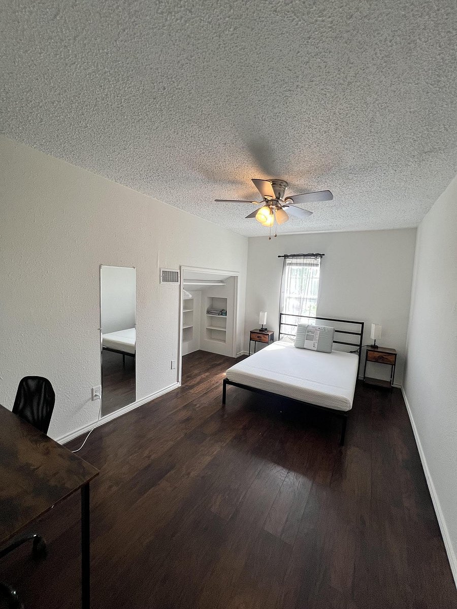 Furnished bedroom with ceiling fan, hardwood-style floors, a window for natural light, and an open closet with built-in shelv