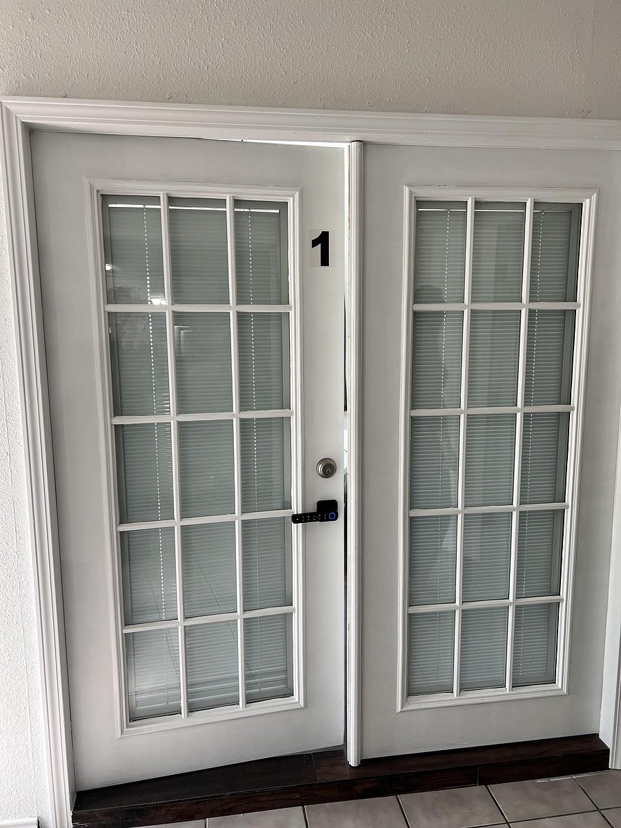 Secure double French-door entry with divided-light glass panels and interior blinds for privacy and natural light.