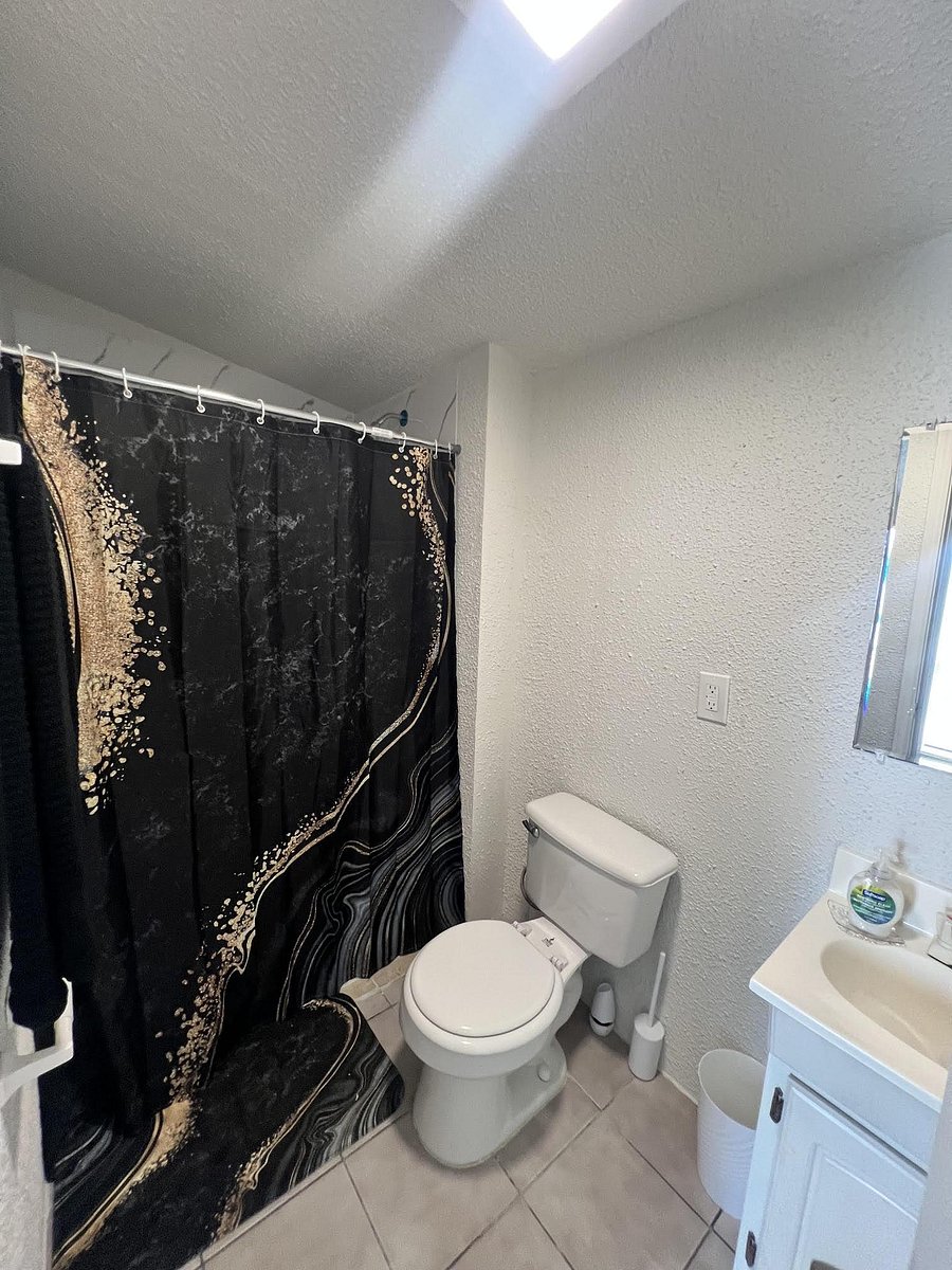 Full bathroom with a tub/shower combo, tile flooring, and a vanity with mirror for daily storage and grooming.