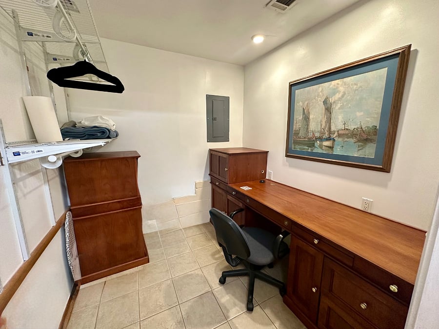 Large closet with hanging shelves, built in desk and chest for storage. 