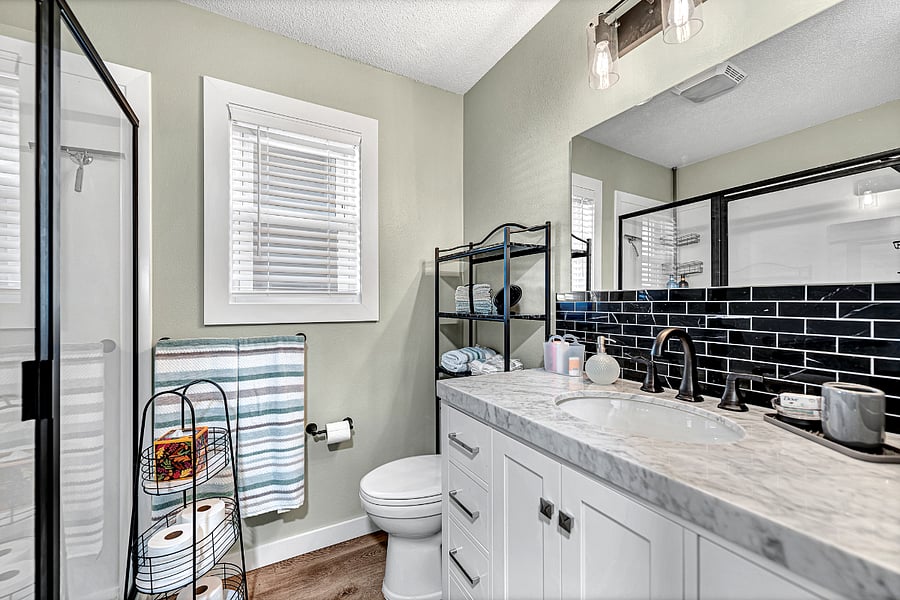 Plenty of nice towels, washcloths, lotion, shampoo and conditioner, hair dryer and curling irons, scales, storage above commode, more.