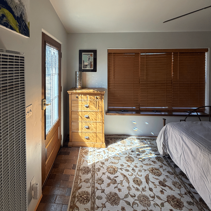 Bedroom showing blinds and door going out to the yard and patio.