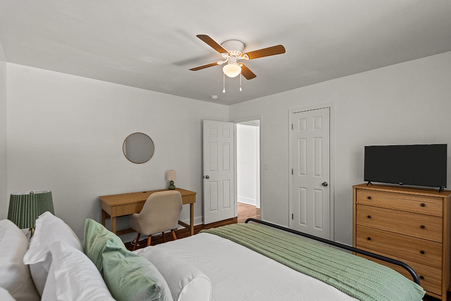 Bedroom with queen bed, work space, and closet
